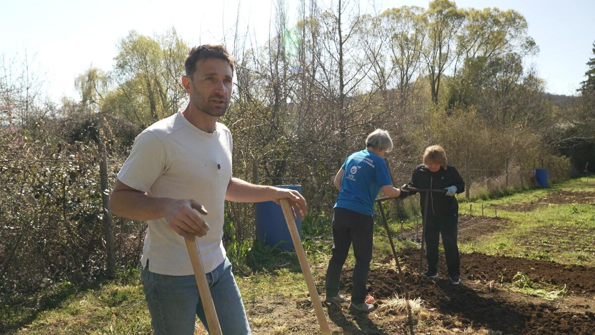 Raphaël Monot au premier plan et deux femmes au second en train de jardiner à Beaumont (Puy-de-Dôme)